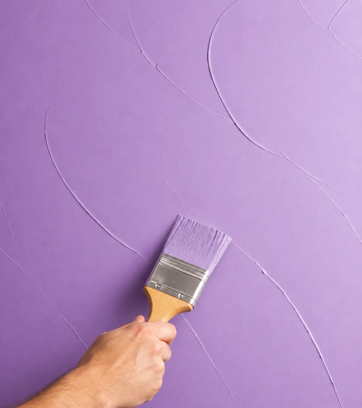 Painter applying smooth lavender-tinted paint